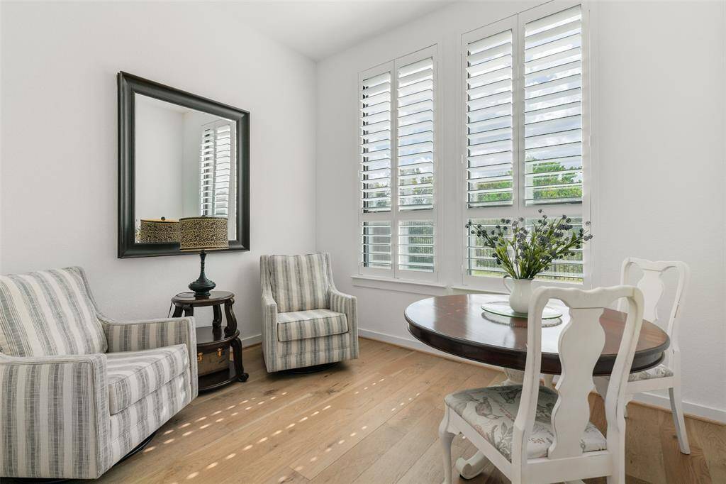 Another flex-use space is designed for use as a study and it showcases elevated 11-foot ceilings, handsome engineered wood floors, neutral paint, and expansive windows with plantation shutters and tranquil greenspace views.