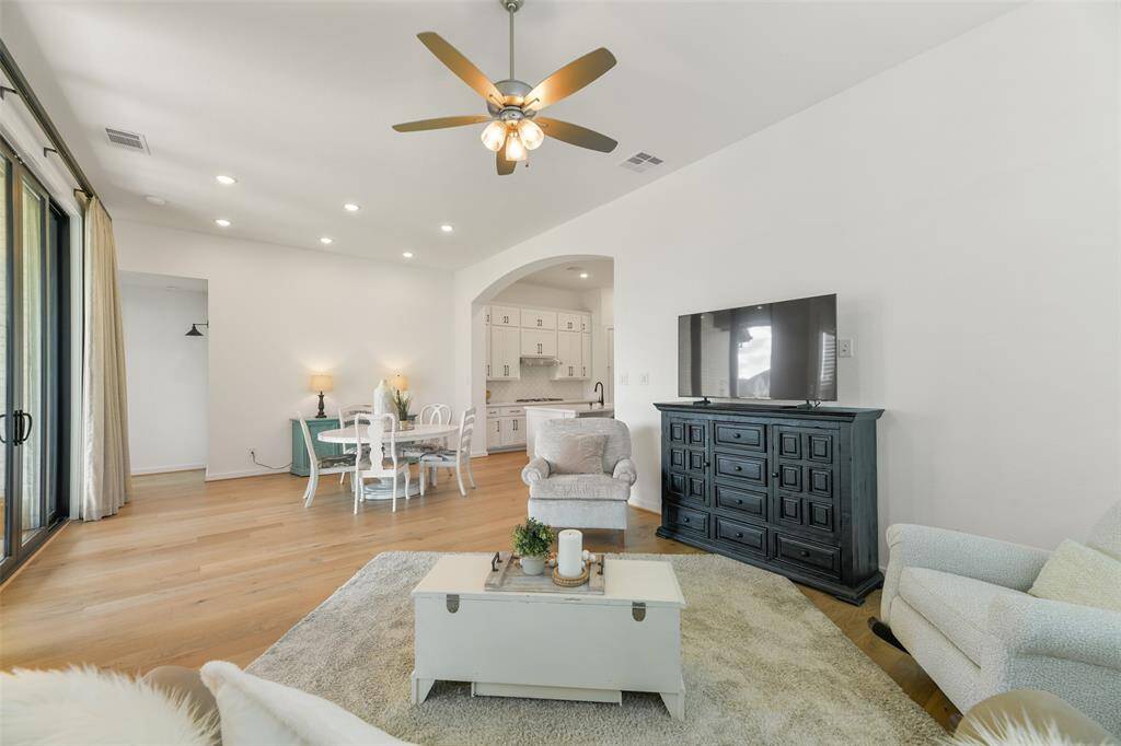 Looking the opposite direction in the family room, note the extra wide sliding door onto the covered back patio area and the seamless transition into the dining area and chef-worthy kitchen.