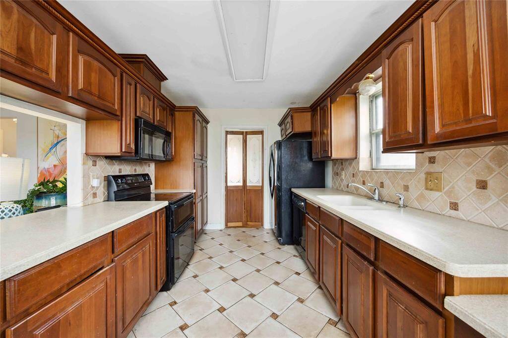 A galley style kitchen features counter space on both sides. The dining room is straight ahead located behind the swing doors. If you have an eye for creativity, you may see the potential to expand this room and create more of a central island.