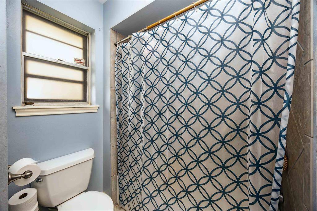 The primary features a tub and shower combination. Imagine a redesign with a new window and possibly a walk-in shower.