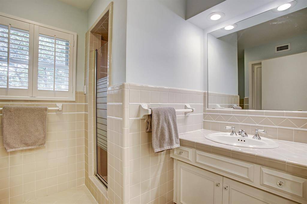 Primary bath has large window and plantation shutters.