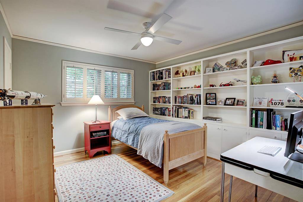 Middle bedroom with wall of built-ins, ceiling fan & two closets.