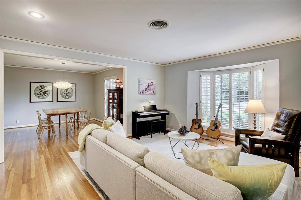 Enjoy fun times in this living room with bay window & plantation shutters