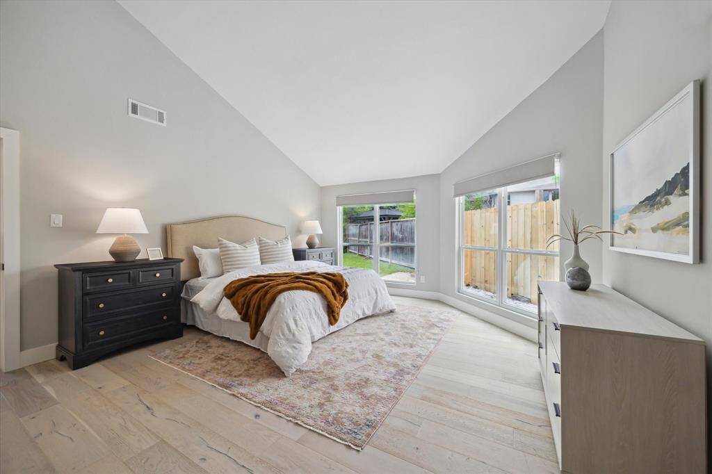 Welcome to your private retreat, tucked along the north side of the home. This spacious suite comfortably accommodates a king-size bed, nightstands, dresser, and even a cozy sitting area just beyond view.