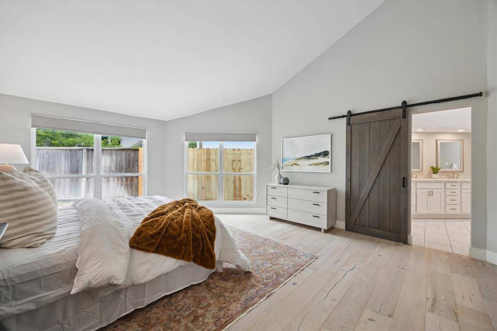 With vaulted ceilings, sunlit serenity, and a thoughtfully designed ensuite accessed by a barn door, this primary bedroom offers everything you need for rest and relaxation.