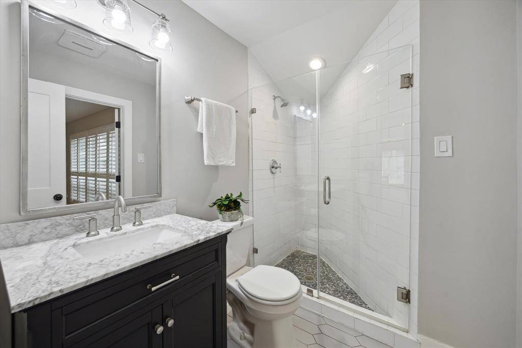 The secondary bathroom is thoughtfully situated with access from both the front bedroom and the foyer, offering flexibility for guests.
