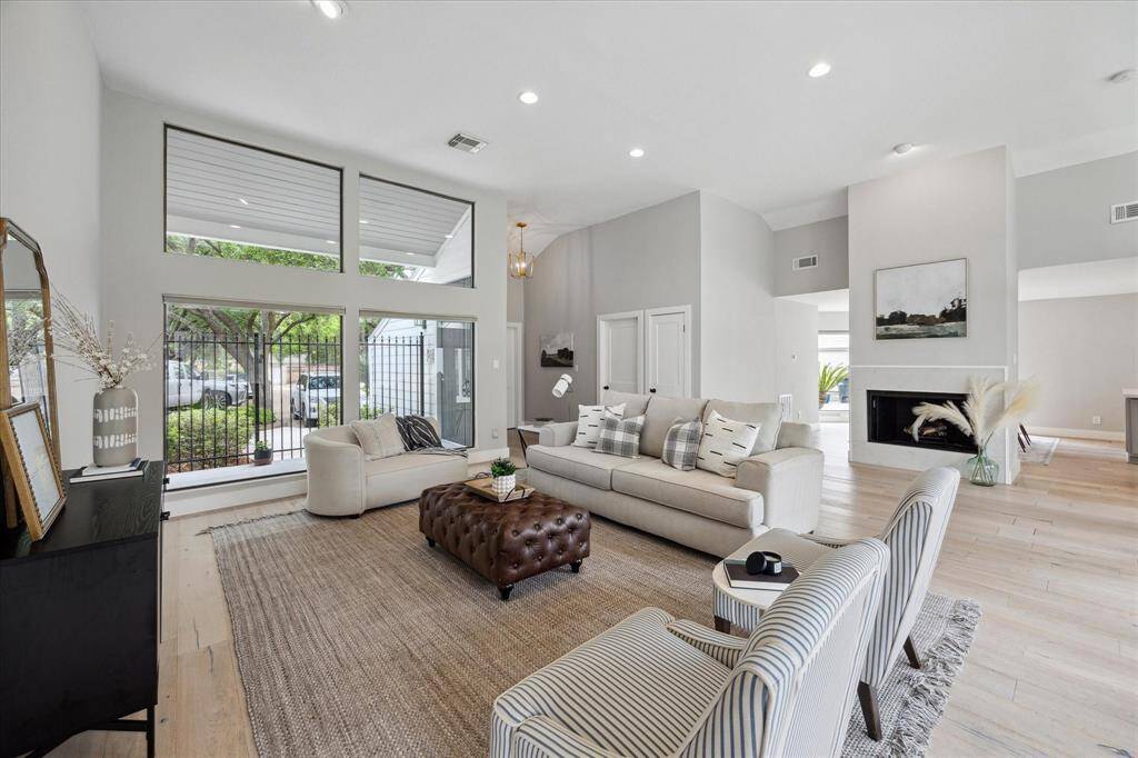 The living room is open and spacious, within windows inviting an abundance of natural light from both the front....