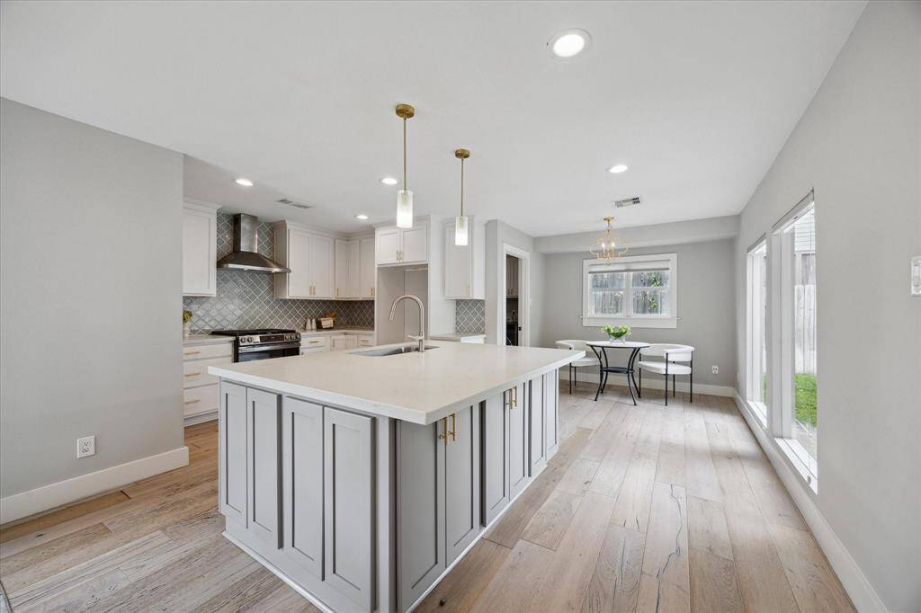 Anchored by a quartz-topped island with built-in storage, the kitchen pairs clean design with everyday functionality and stainless steel finishes.