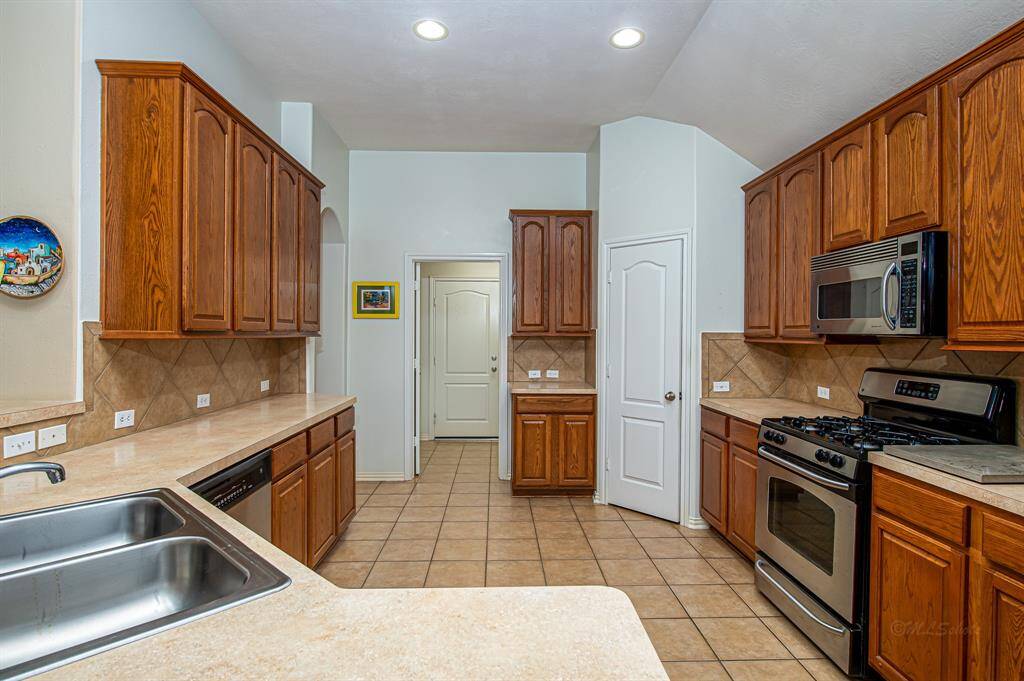 Your kitchen features expansive counter space, abundant storage, and a brand-new dishwasher. The open layout connects to the utility room and garage, creating a practical and inviting space