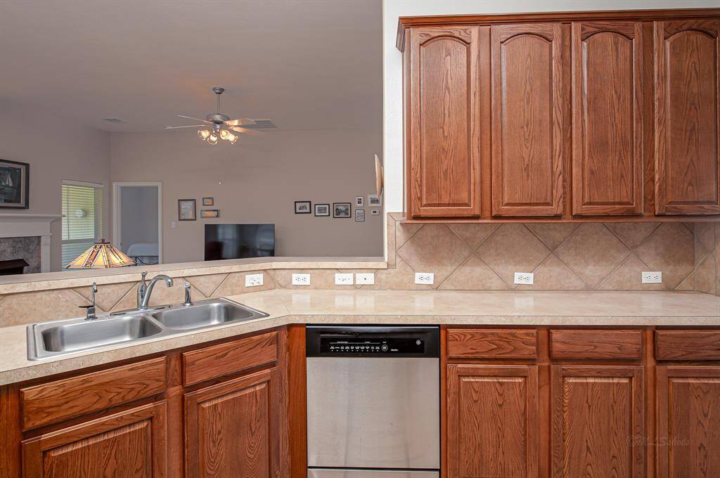 This kitchen view captures the essence of togetherness. Whether cooking or enjoying a meal on the barstools, you're part of the action in the family room, sharing the warmth of the fireplace, the pond view, and the TV experience.