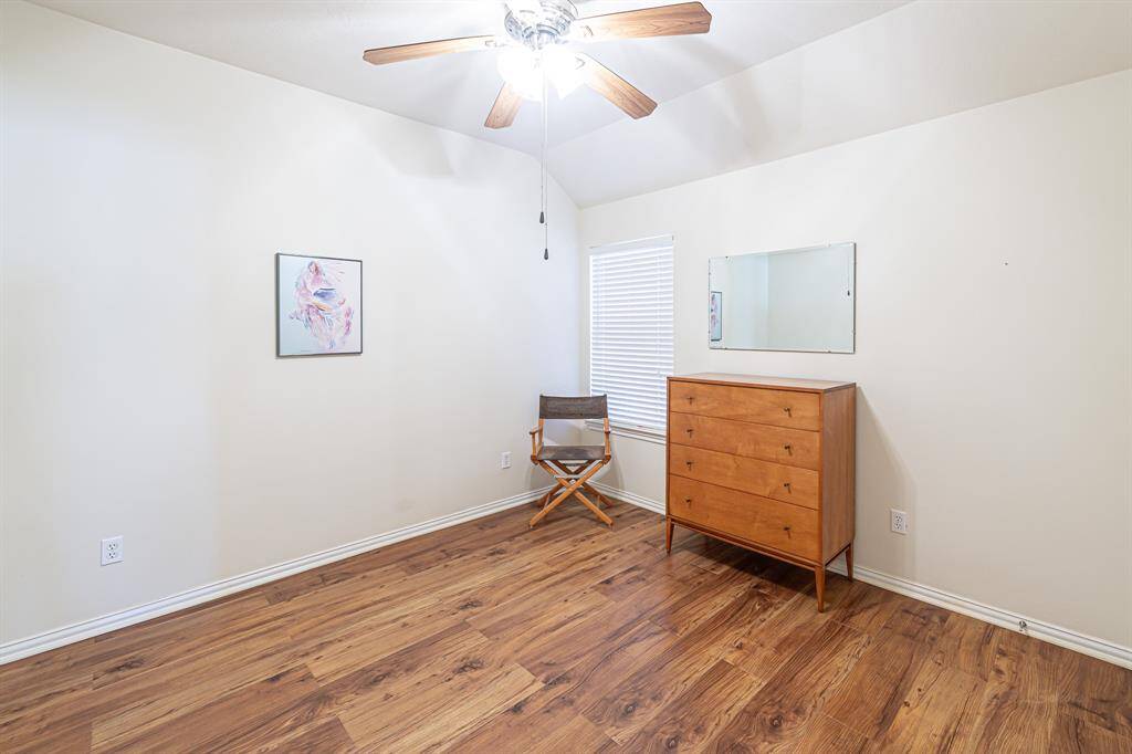 This secondary bedroom showcases beautiful flooring and high ceilings