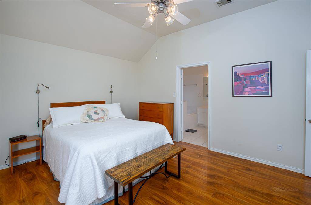 Alternate view of the spacious primary with en suite bath, high ceilings and beautiful floors!