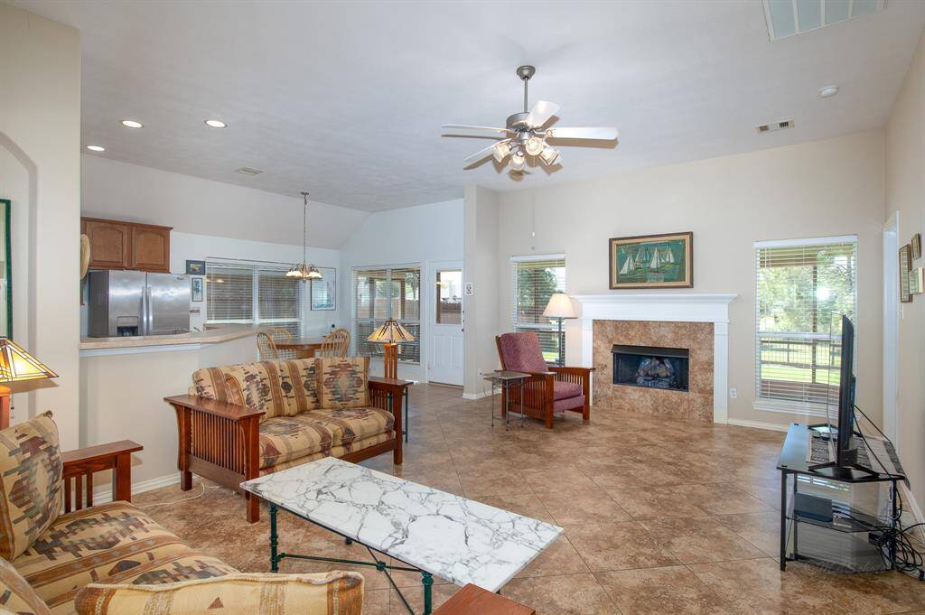 Your new welcoming living space features all tile, a striking tall art niche and a cozy gas fireplace! The neighborhood pond can be seen from all of the back windows and the tall ceilings add that grand feeling to the space!