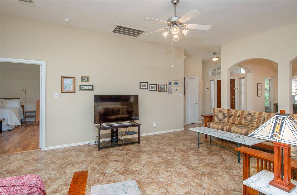 This view of the living space shows off the beautiful arches separating the living room from the flex room.  It also illustrates the proximity of the primary bedroom.