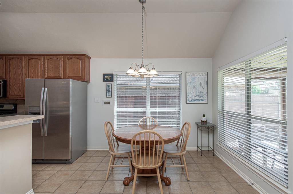 This bright and airy breakfast room boasts tall ceilings and two large windows, including one showcasing serene pond views. Enjoy easy access from the kitchen and living room, making it perfect for morning meals or relaxing moments