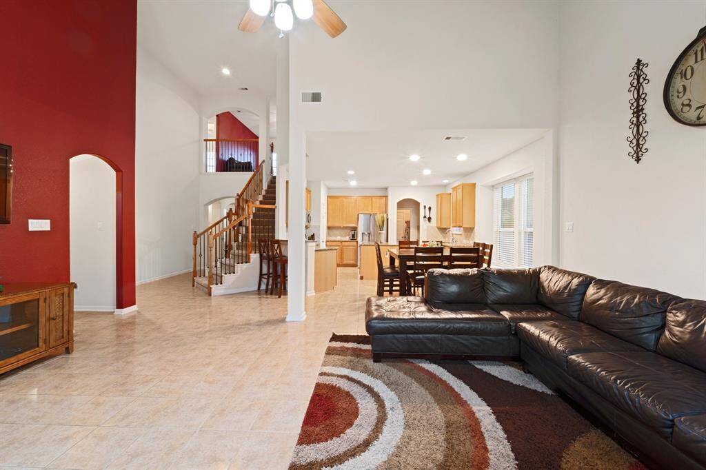 Sweeping view of the open living layout from the family room—highlighting the connected flow between kitchen, dining, and stairway.