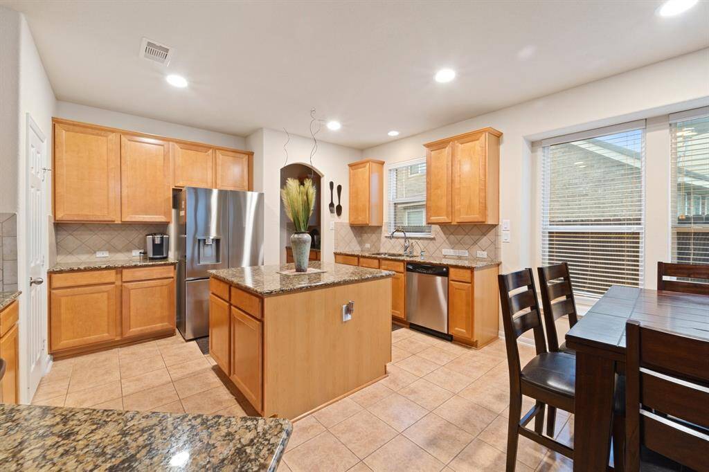 Modern kitchen with granite countertops, a center island, and stainless steel appliances—designed for both style and function.