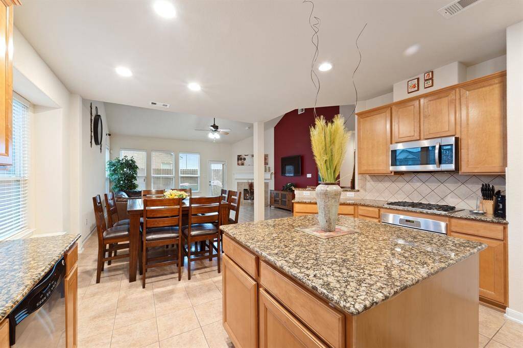 Granite island anchors the kitchen, with clear views of the dining and living areas—great for hosting and everyday living.