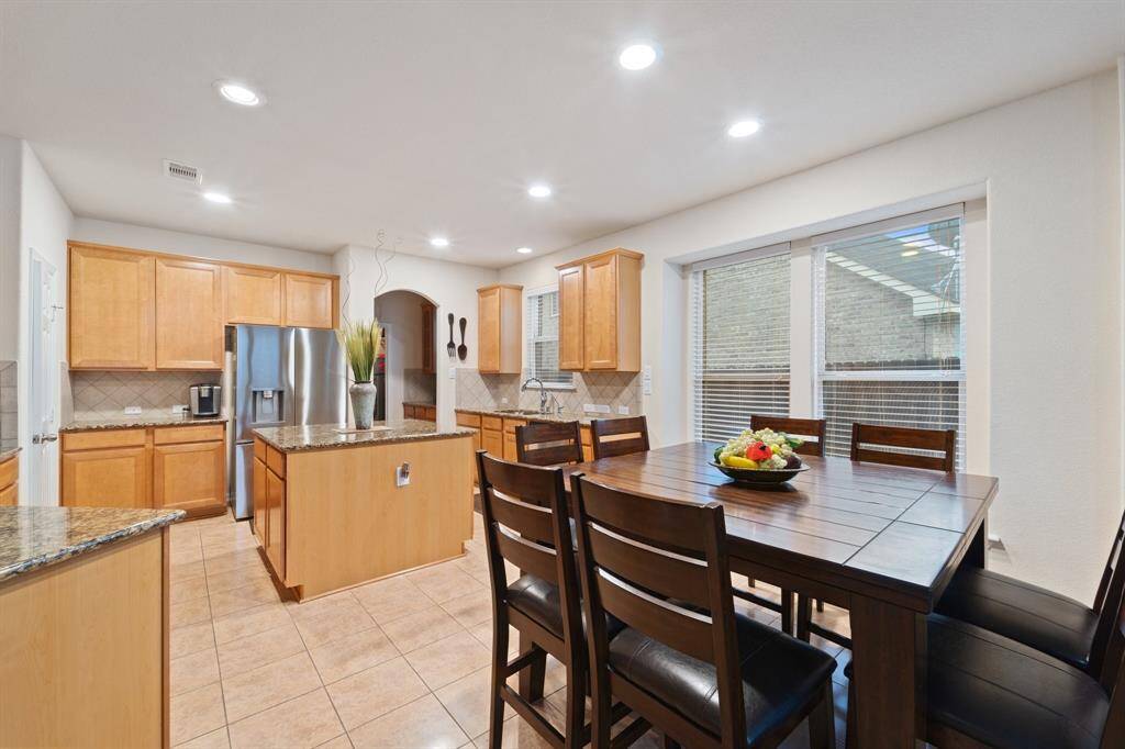 Bright breakfast area with large windows, connected to the open kitchen and perfect for casual meals.