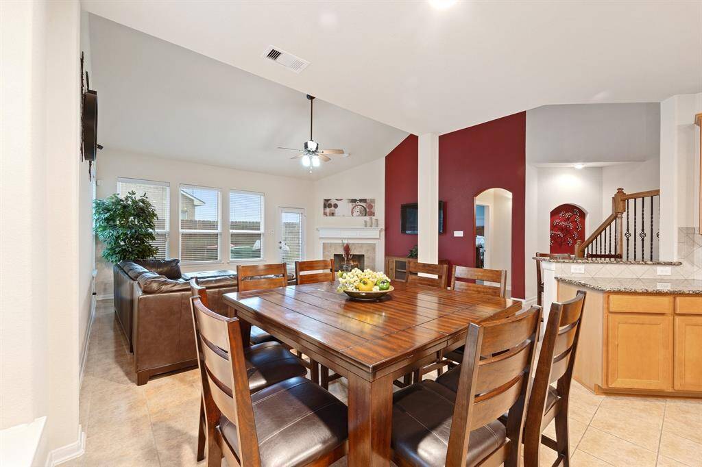 Dining area provides views of the living space and kitchen, all set under recessed lighting with an open layout design.