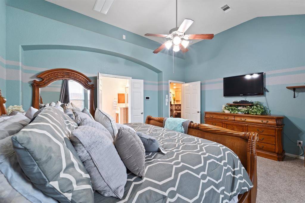 The primary suite features a cozy layout with elegant arch detailing, ceiling fan, and easy access to the en-suite bath.