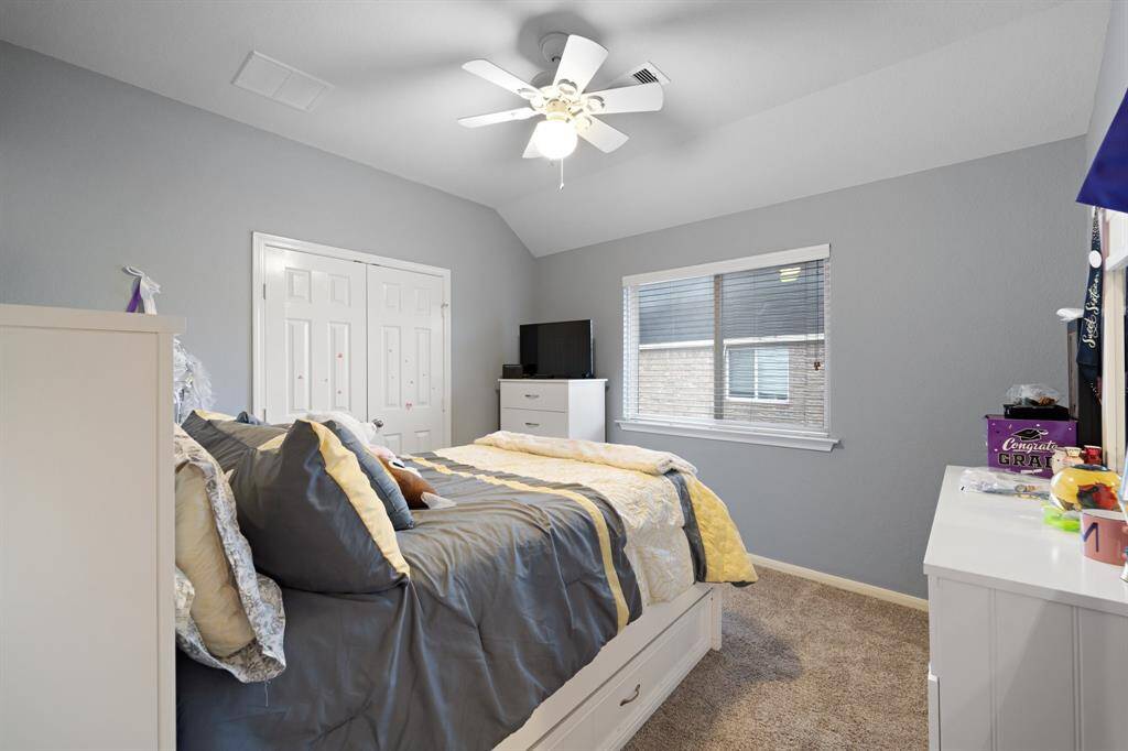 Well-sized secondary bedroom with a wide window and double door closet for convenient storage.
