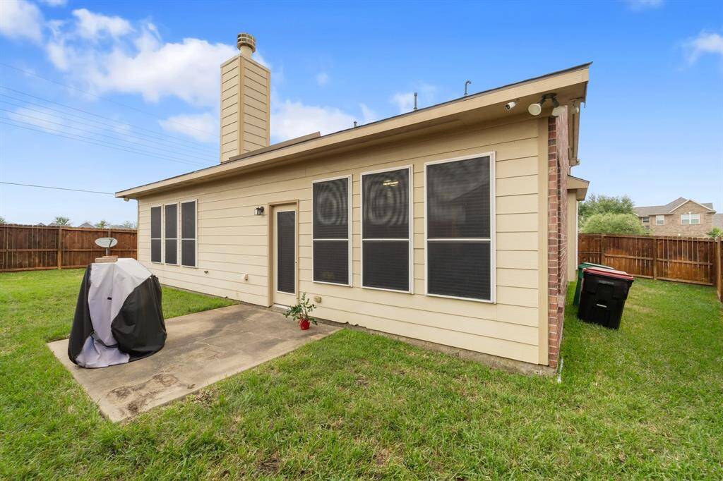 Back elevation of the home features multiple windows for natural light and a back door leading directly to the patio.