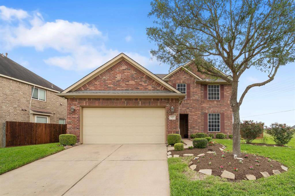 Charming brick elevation with professional landscaping and mature tree—this home offers great curb appeal with a double-wide driveway and two-car garage.