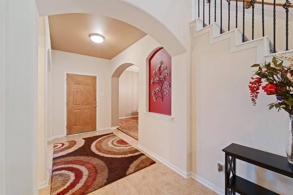 Inviting entryway showcases tile flooring, warm neutral tones, and unique architectural details.