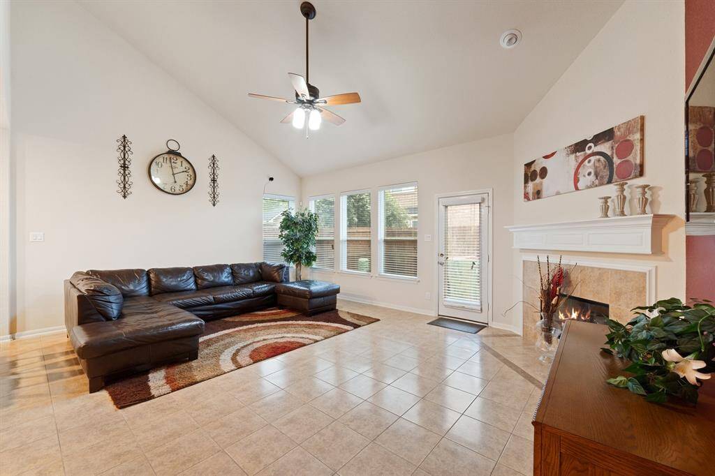 Comfortable family room with a cozy fireplace, large windows, and direct access to the backyard—ideal for relaxing or entertaining.