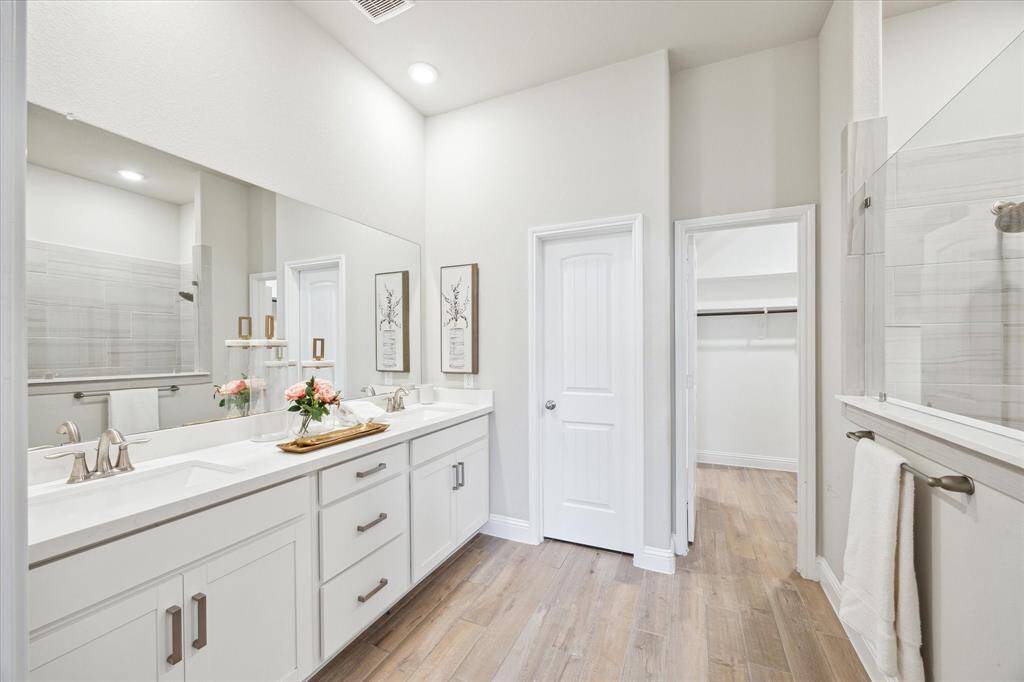Primary bathroom with double vanity and quartz countertops.