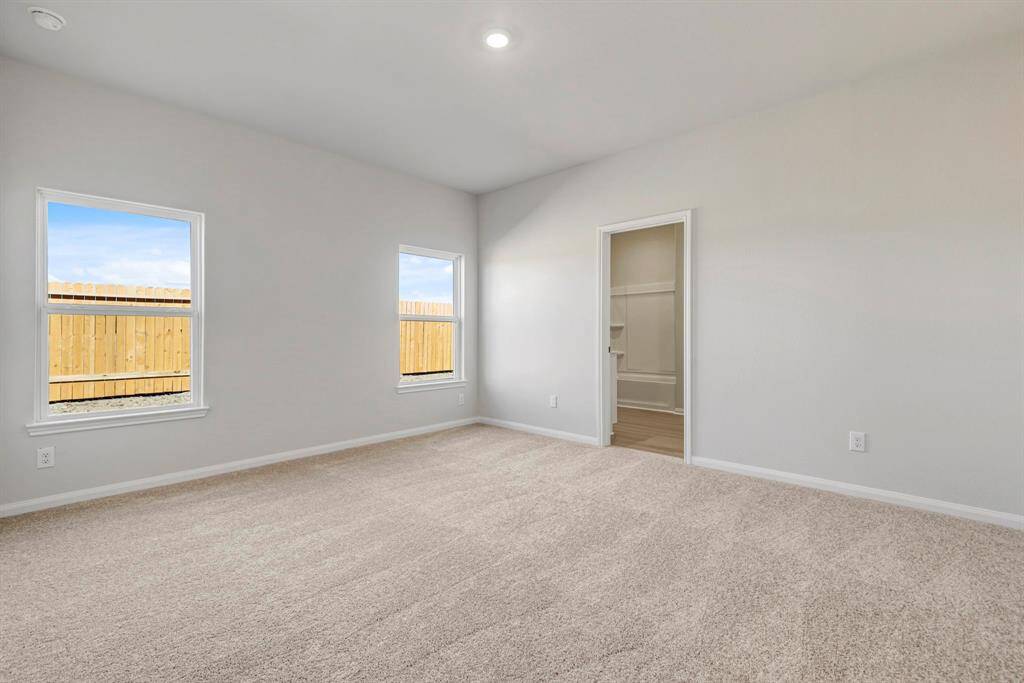 Large, primary bedroom with beautiful windows.