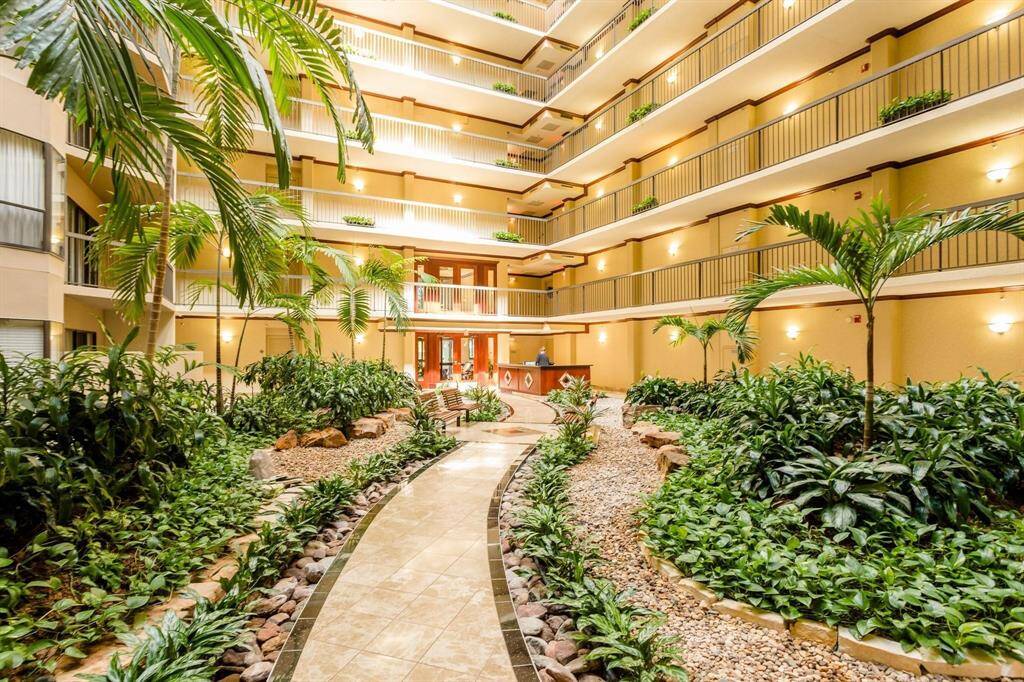 Atrium filled with palms and tropical landscaping.