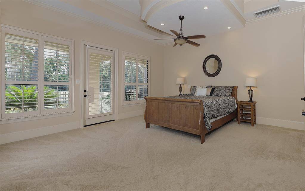 Main level, luxurious primary retreat with incredible ceiling details, relaxing views and access to the sprawling covered patio