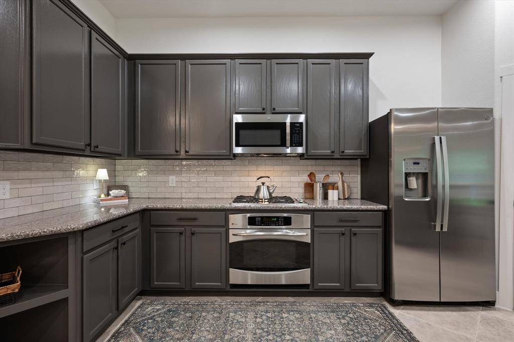 The kitchen is thoughtfully designed with a single oven paired with a gas cooktop above, and a built-in microwave.