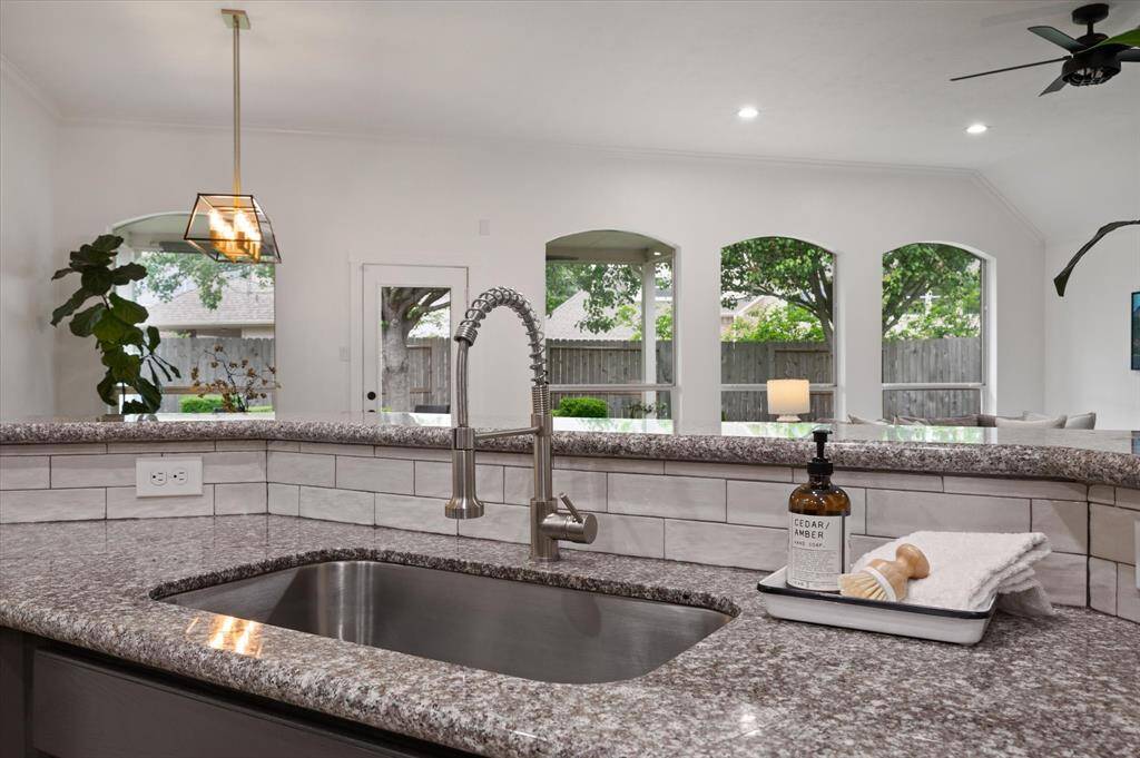 The single-basin under-mount sink is perfectly positioned beneath the expansive breakfast bar, offering both a convenient space for meal prep and a casual dining area. Its open design fosters easy conversation and effortless entertaining.