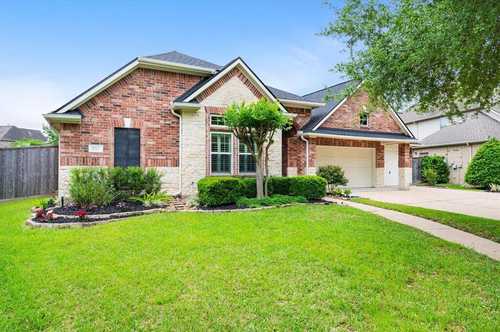 Drive up on the extended double-wide driveway, which seamlessly expands to a triple-wide layout and leads to a spacious three-car garage. The design includes a two-car bay alongside a separate one-car bay—offering ample parking and flexibility for multiple vehicles or additional storage.