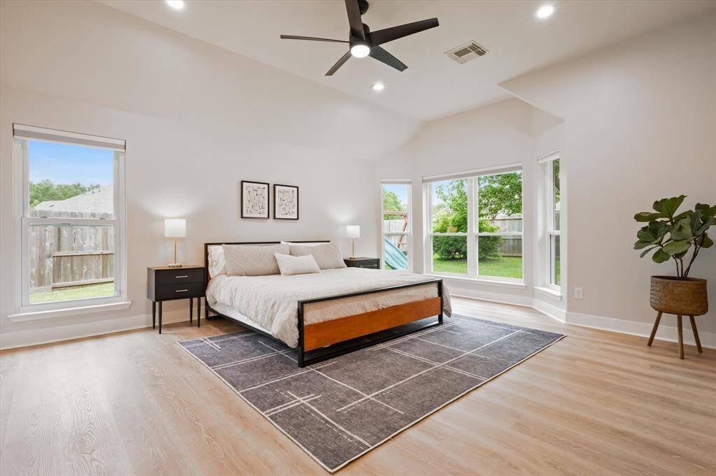 Retreat to the effortless comfort of the Owner’s Suite, featuring wood-look flooring, recessed lighting, and sophisticated decorator paint. A beautiful bay of windows fills the room with natural light and offers the perfect spot for a cozy seating area. These windows were also replaced in 2023.