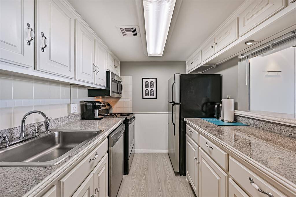 Updated kitchen with stainless steel appliances and granite tile countertops.