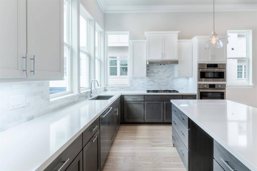 Expansive kitchen with large windows and huge island. Similar plan and finishes.