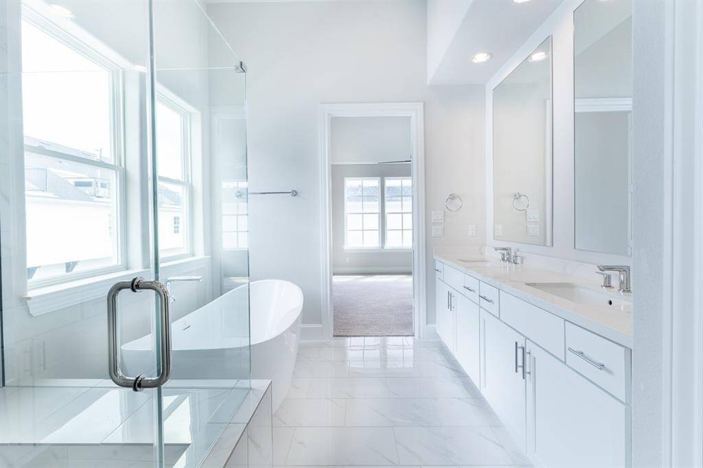 Frameless shower door, 6' tub, (not freestanding), and separate toilet room.Similar plan and finishes.