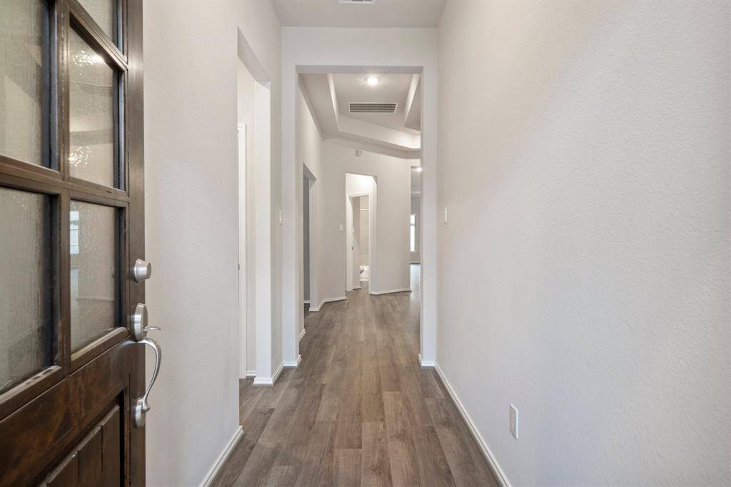 Front entry hallway has high ceilings and vinyl planks that are all throughout the home except bedrooms.