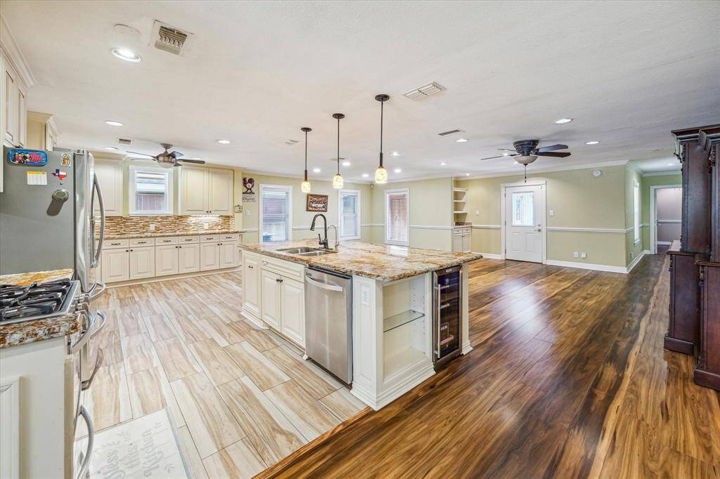 The kitchen boasts a large granite island complete with a wine cooler and built-in dishwasher—perfect for entertaining and everyday convenience.