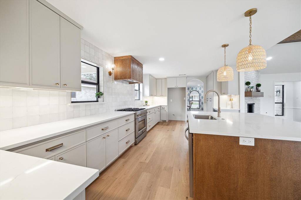 Stylish kitchen featuring rattan lighting, custom-built soft-close cabinets, under-cabinet lighting, and an oversized sconces for an elegant touch.
