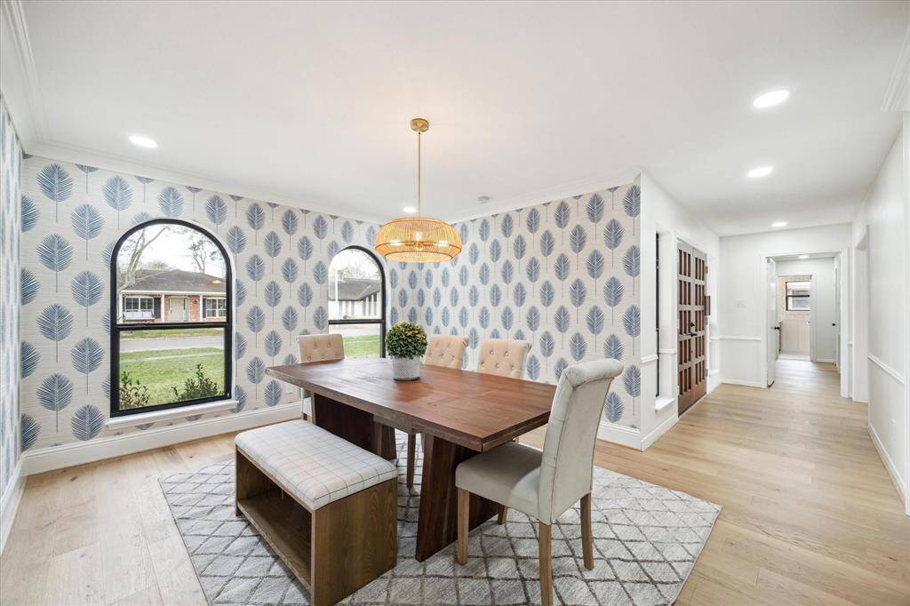 Charming dining room with chic designer wallpaper and abundant natural light.
