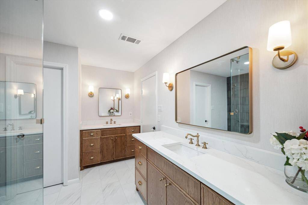Elegant primary bathroom featuring Italian and Spanish porcelain tiles, a quartz countertop, and designer gold lighting.