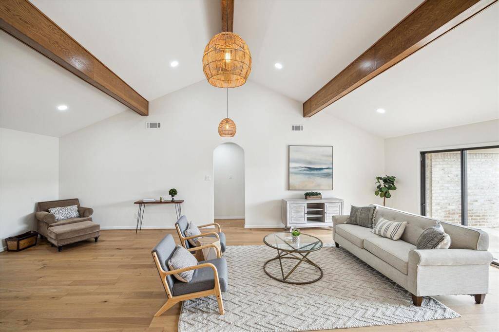 Airy living room with rattan lighting, a vaulted ceiling, and abundant natural light.