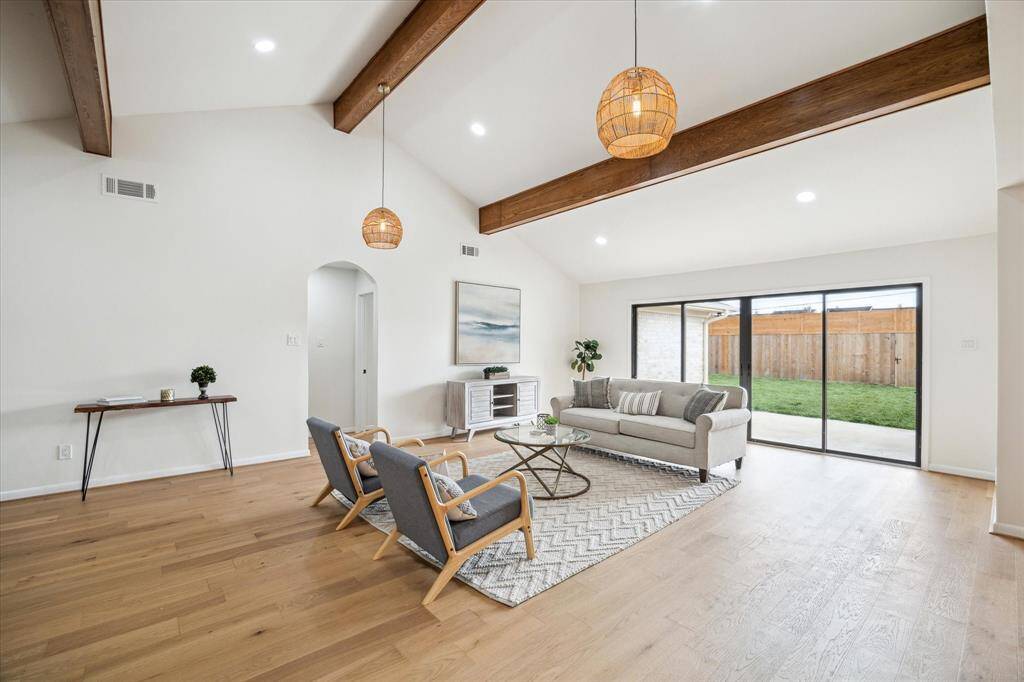 Stylish living room with rattan lighting, a 12’ wide glass sliding door, and abundant natural light.
