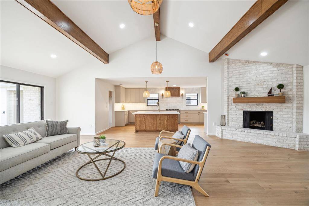Bright living/kitchen area with a fireplace, vaulted ceiling, and abundant natural light.