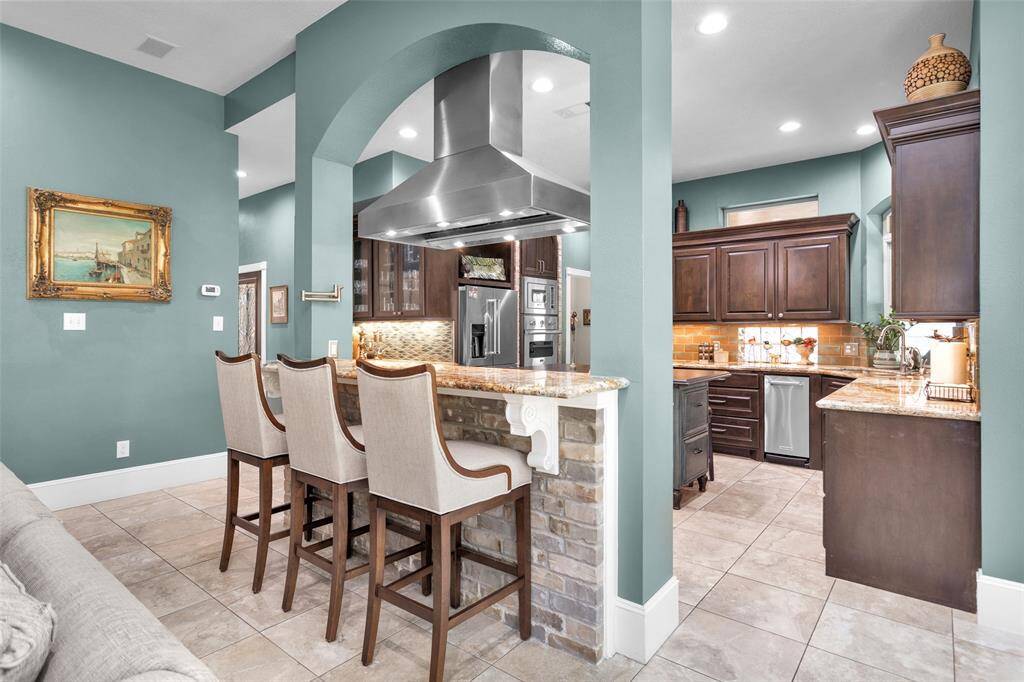 Open kitchen concept with breakfast bar separating it from the family room